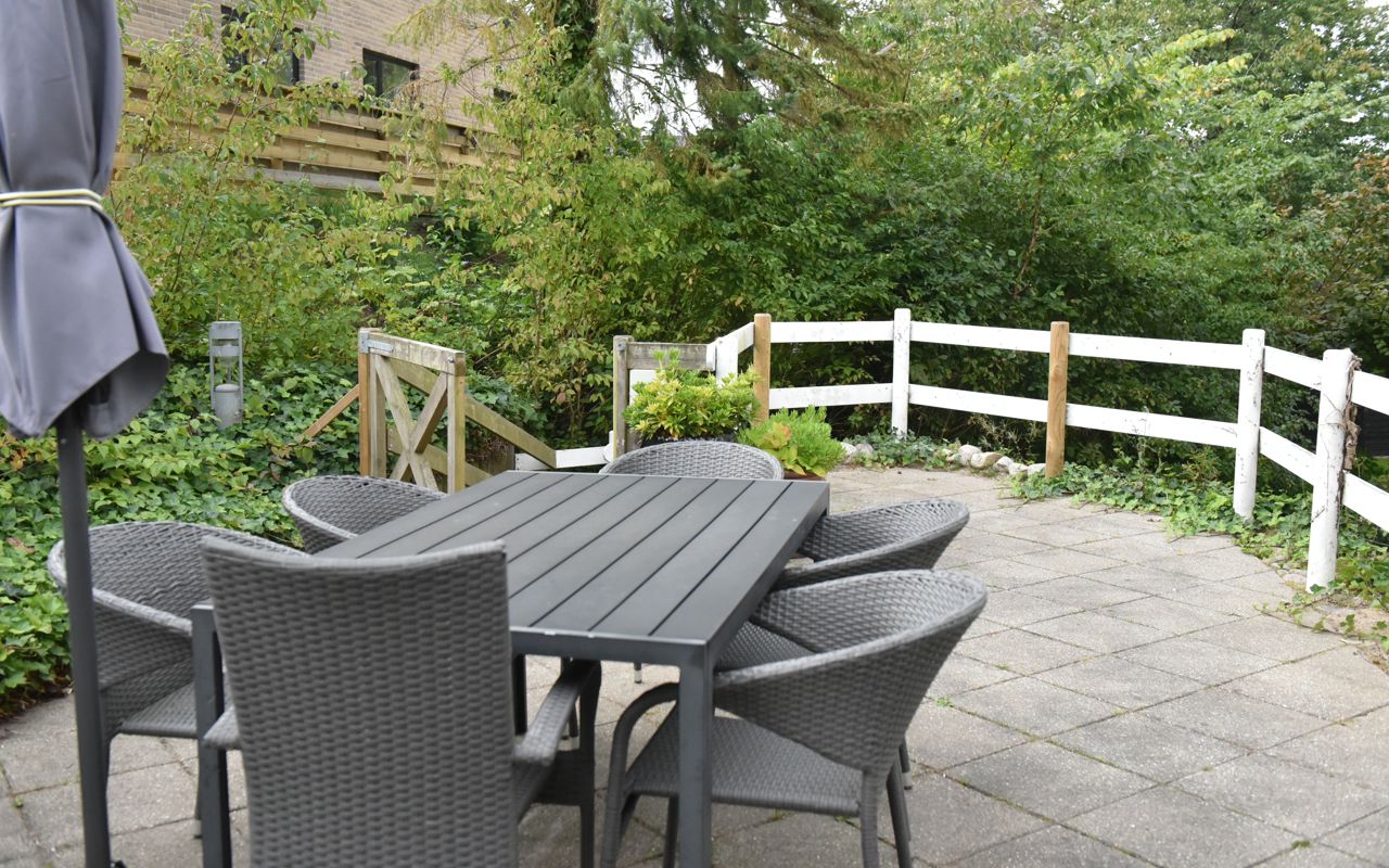 Terrasse med havemøbler og parasol hos Kristrupcentret