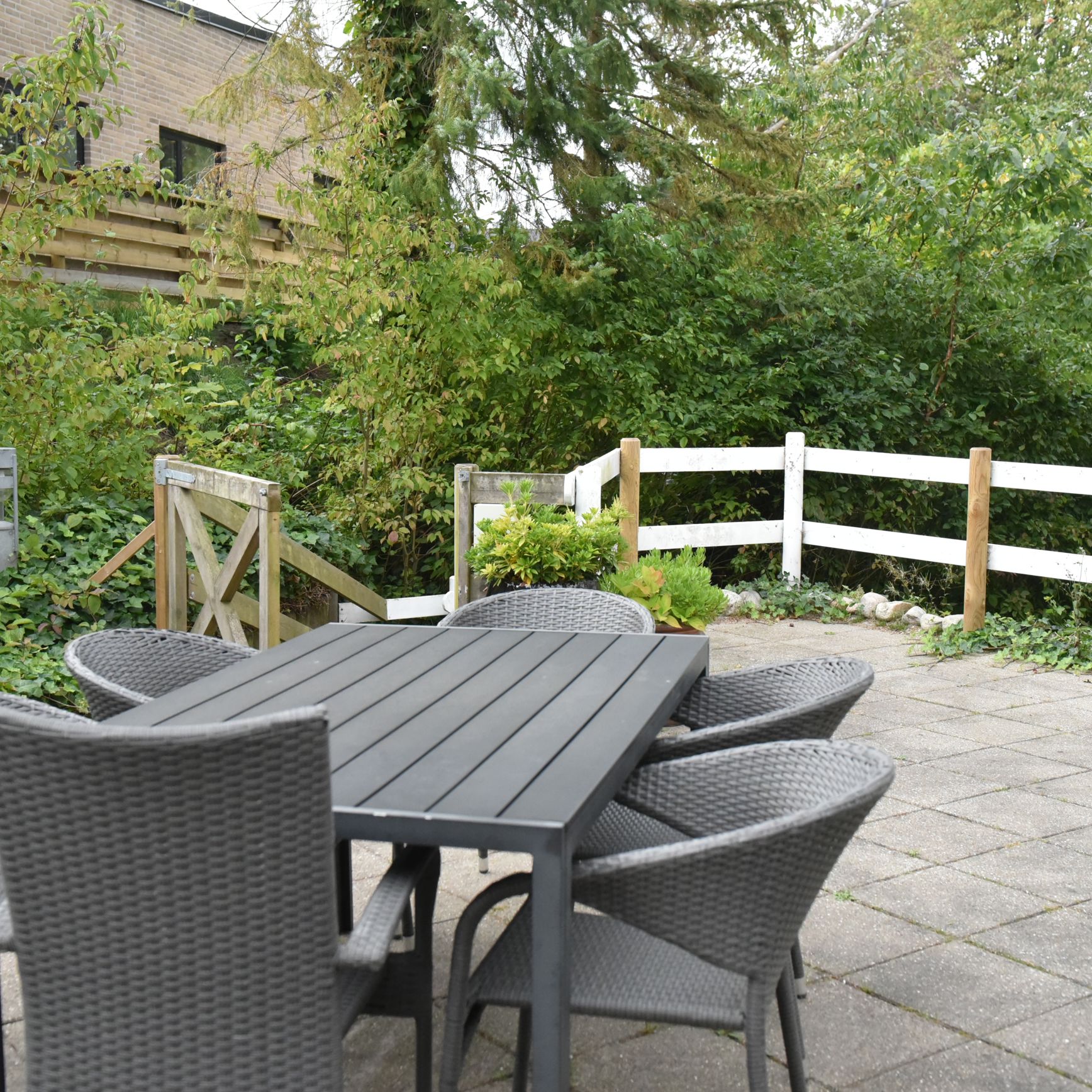 Terrasse med havemøbler og parasol hos Kristrupcentret