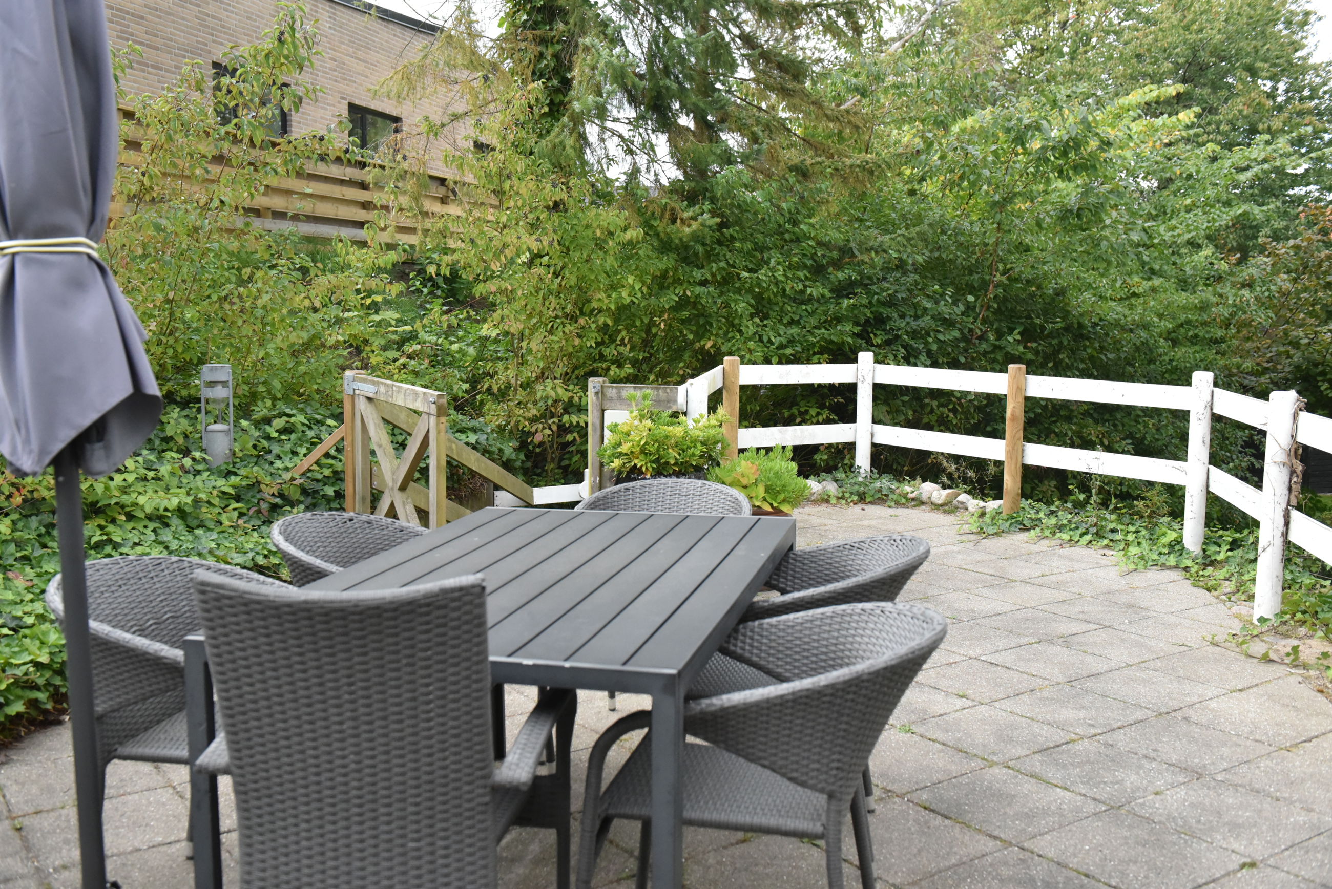 Terrasse med havemøbler og parasol hos Kristrupcentret