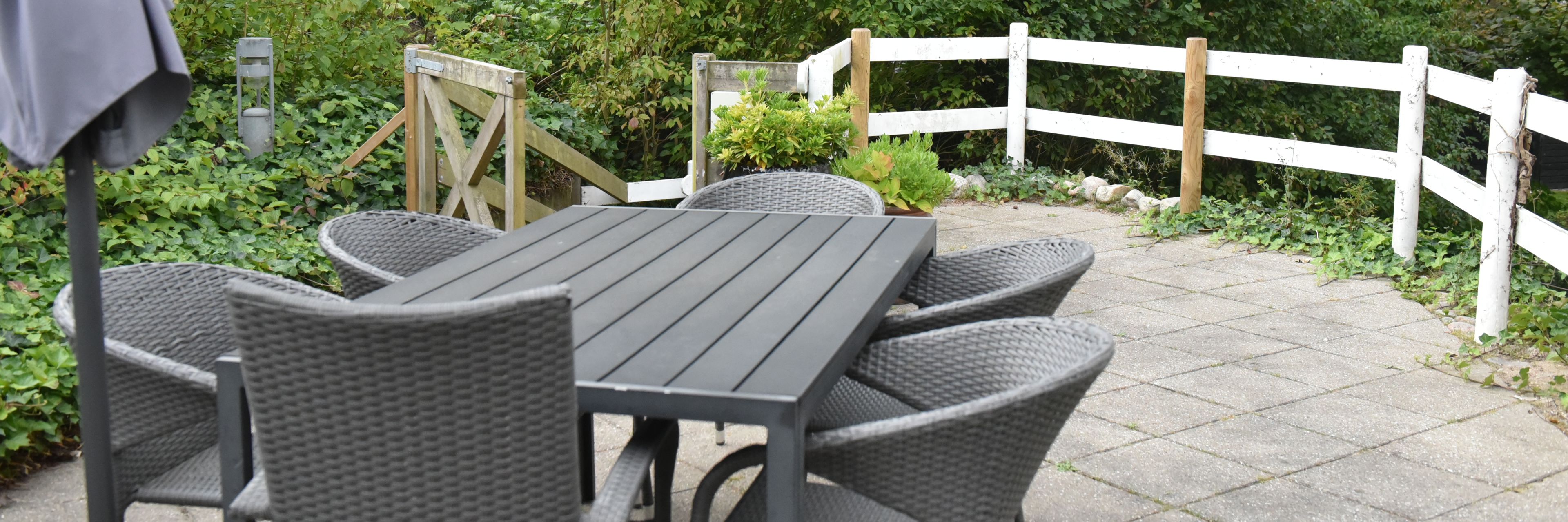 Terrasse med havemøbler og parasol hos Kristrupcentret