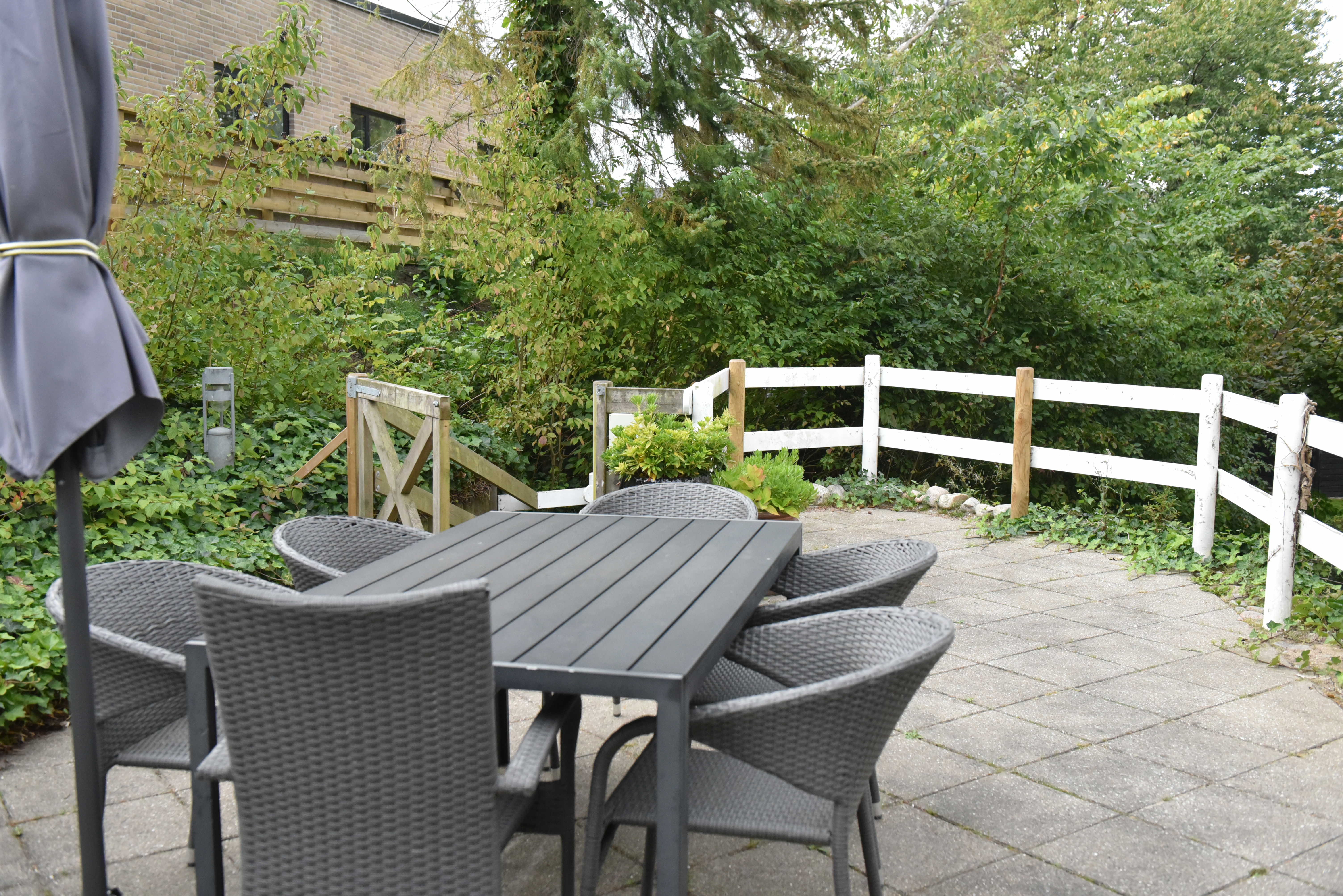 Terrasse med havemøbler og parasol hos Kristrupcentret